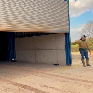 Man closing door to grain store on farm